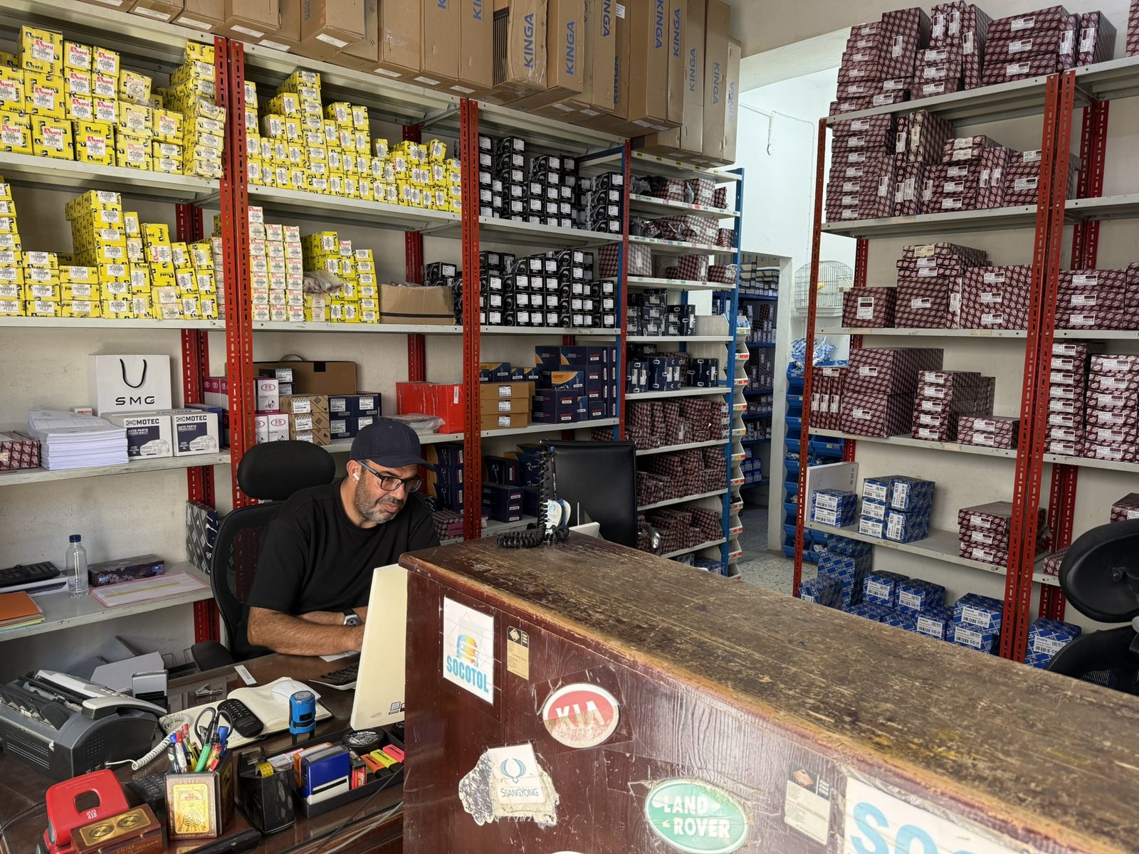 Le comptoir de l'agence de Sfax : rayonnages de pièces et prise de commande.